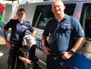 Policjant, policjantka i dziecko ubrane w strój policyjny.